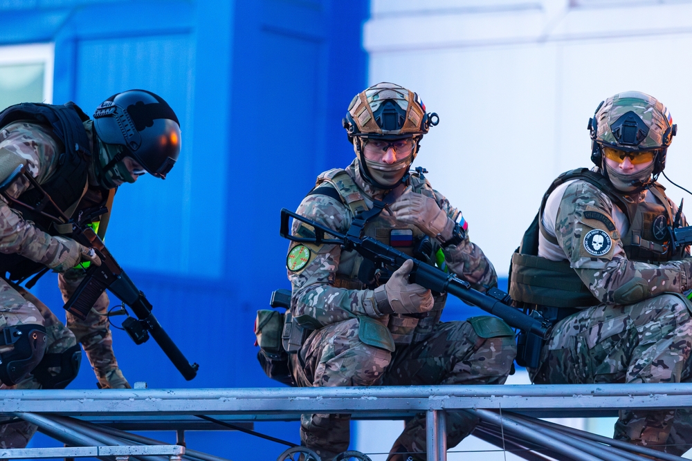 Three soldiers in combat gear sit down